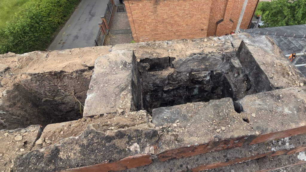 Damaged lead flashing around a chimney causing potential roof leaks.