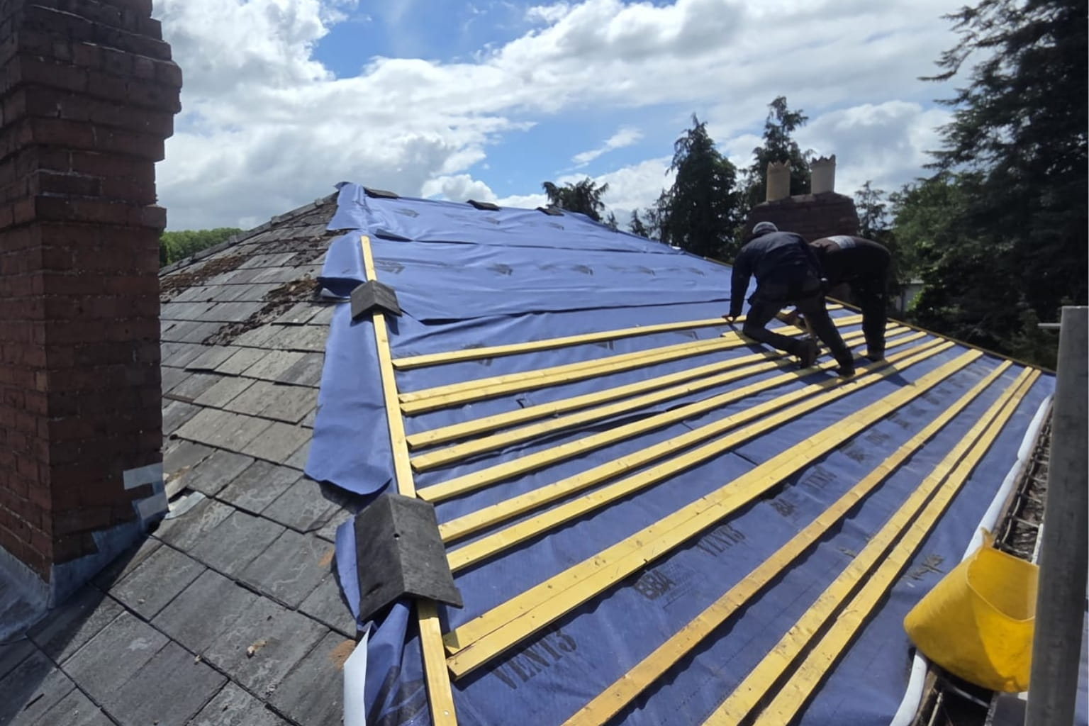 Roof replacement project with scaffolding and roofing workers.