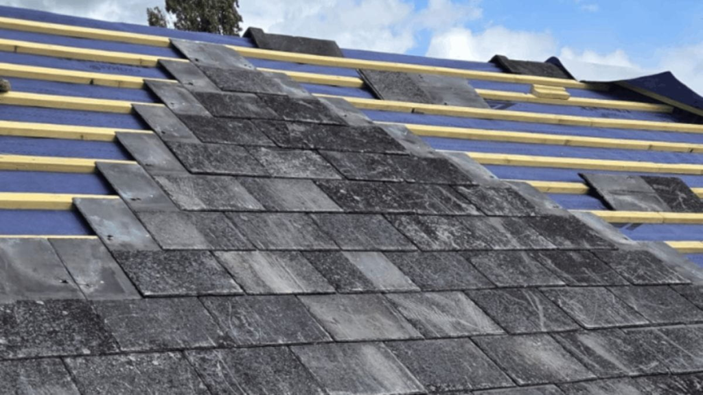 Slate tiles being installed during roof replacement.